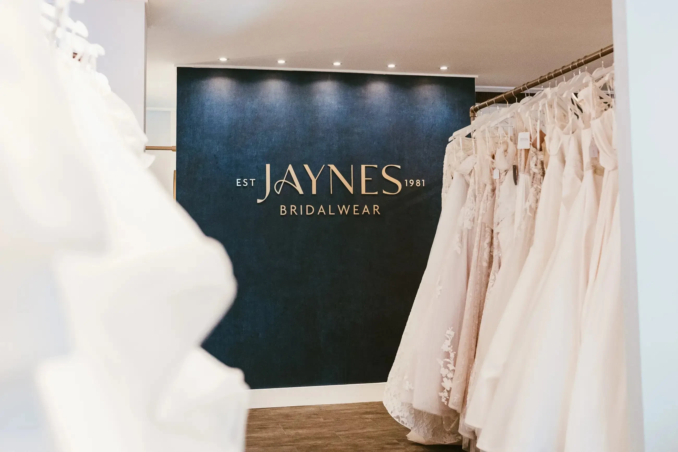 image shows a rack of bridal gowns at jayne's bridalwear