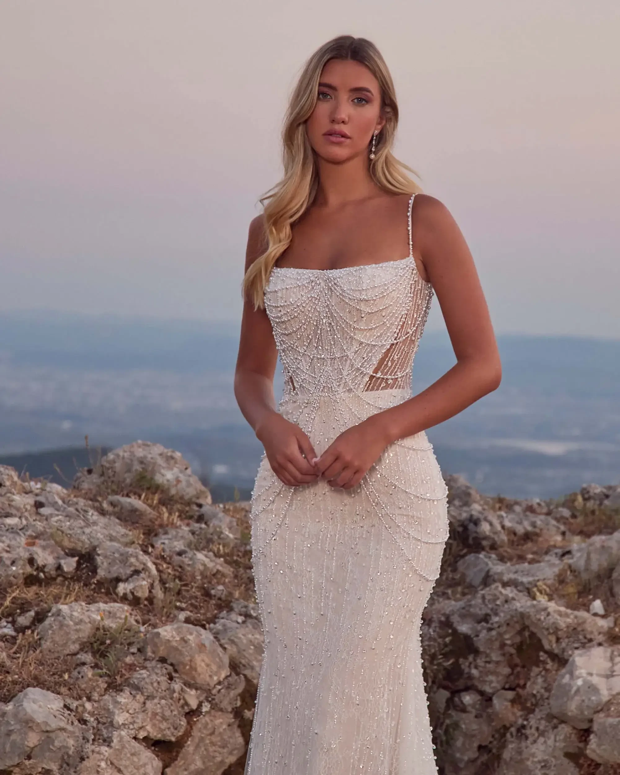model is wearing a sleeveless fit and flare wedding dress