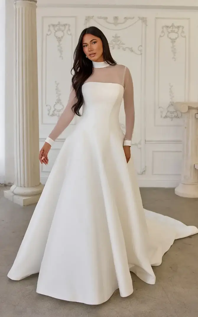 model is wearing an a-line long sleeve high neck wedding dress