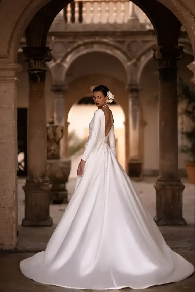 model is wearing a long sleeve a-line wedding dress with a plunging neckline